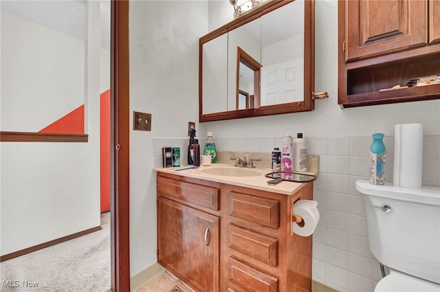 bathroom featuring vanity, tile walls, and toilet