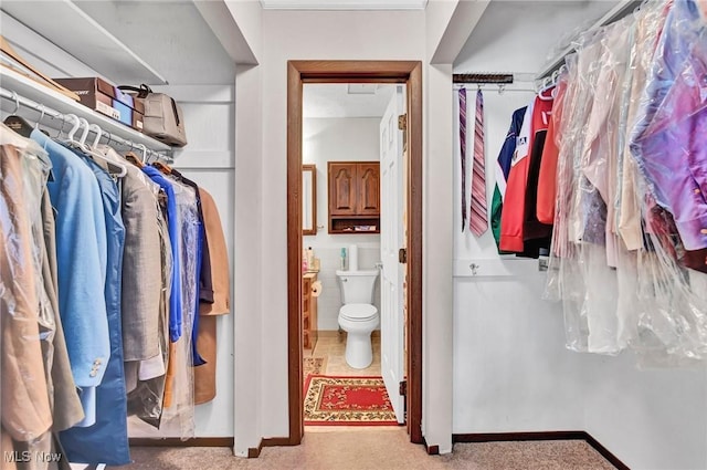 walk in closet featuring light carpet