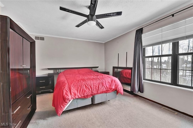 bedroom featuring crown molding, ceiling fan, light carpet, and a textured ceiling