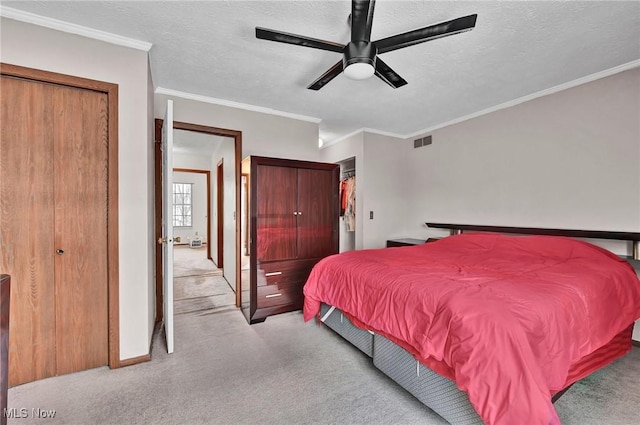 carpeted bedroom with crown molding, ceiling fan, and a textured ceiling