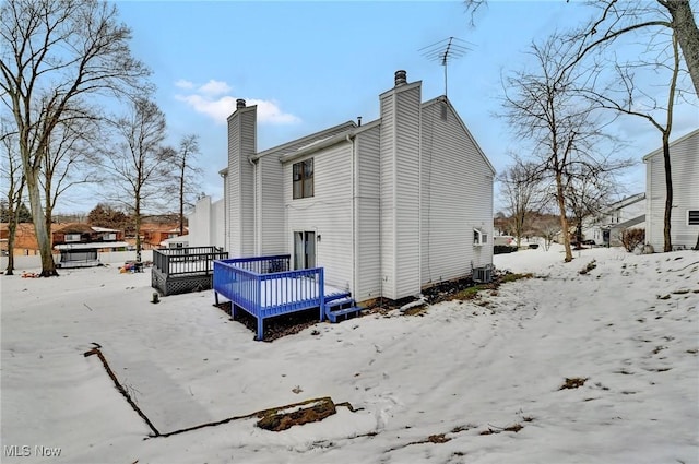 snow covered property with a wooden deck and central air condition unit