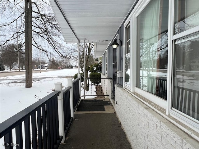 view of snow covered back of property