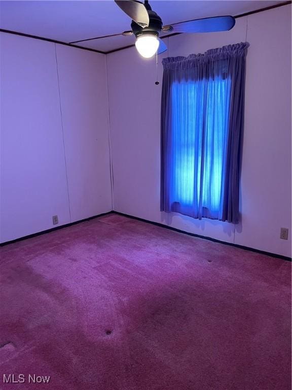 carpeted spare room with ceiling fan