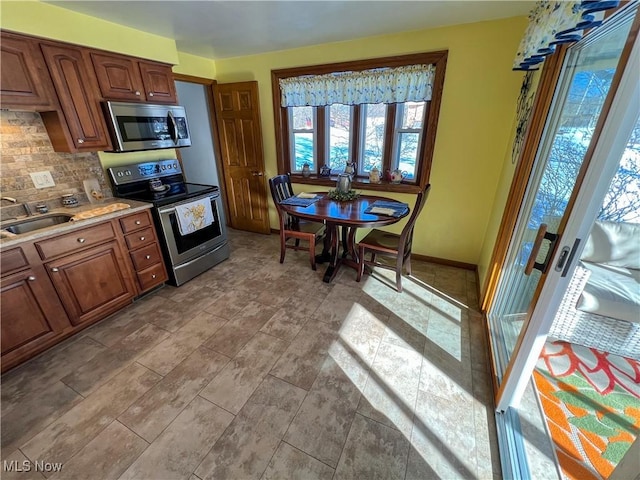 kitchen featuring appliances with stainless steel finishes, sink, and decorative backsplash