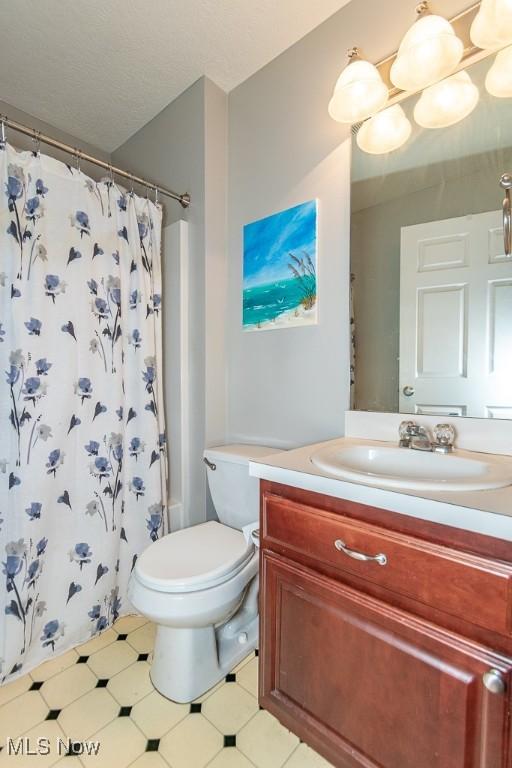 bathroom with vanity, a shower with curtain, a textured ceiling, and toilet