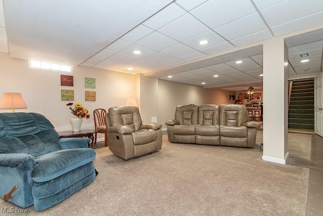 living room featuring a drop ceiling and carpet flooring