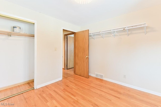 unfurnished bedroom featuring hardwood / wood-style flooring and a closet