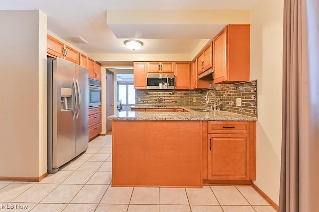 kitchen featuring sink, backsplash, kitchen peninsula, stainless steel appliances, and light stone countertops