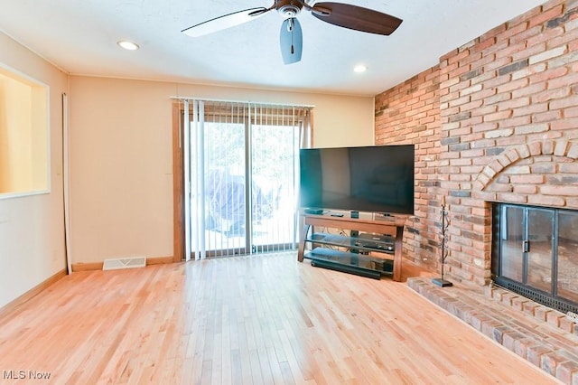 unfurnished living room with wood-type flooring, ceiling fan, and a fireplace