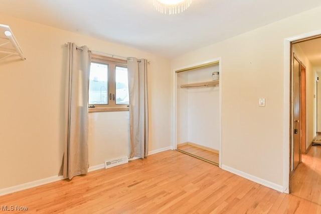 unfurnished bedroom with light wood-type flooring and a closet