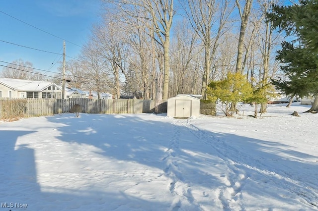 yard covered in snow with a storage unit