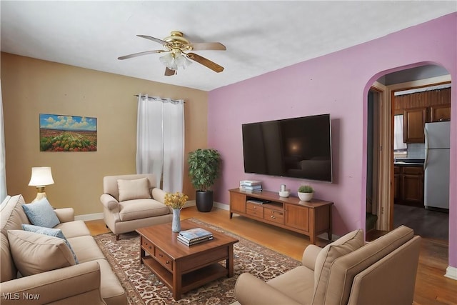 living room with ceiling fan and light hardwood / wood-style flooring