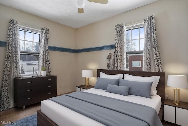 bedroom with dark hardwood / wood-style flooring and ceiling fan