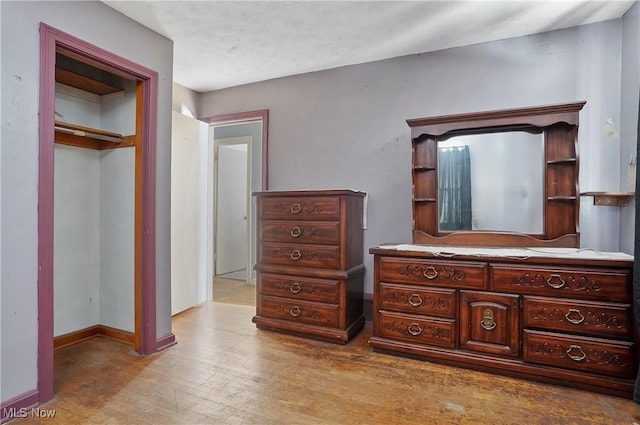 unfurnished bedroom with a textured ceiling and light wood-type flooring