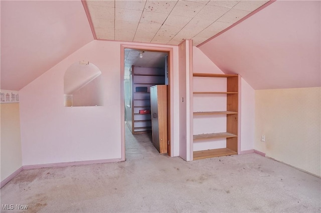 bonus room featuring light colored carpet and vaulted ceiling