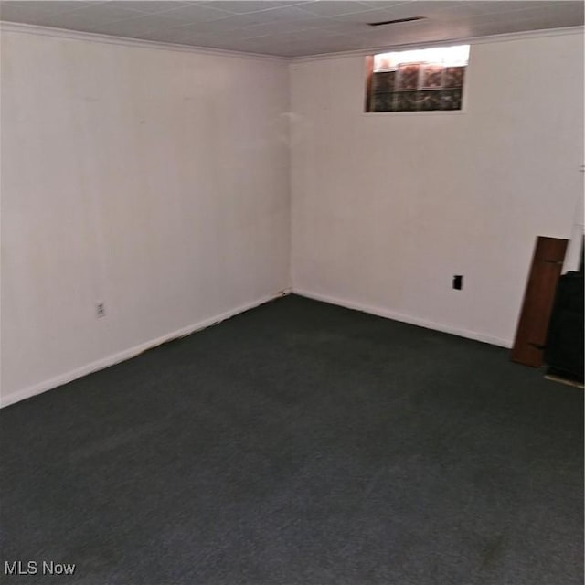 basement featuring crown molding and dark colored carpet