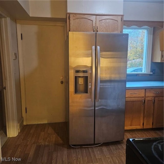 kitchen featuring dark hardwood / wood-style flooring, black electric range oven, and stainless steel fridge with ice dispenser