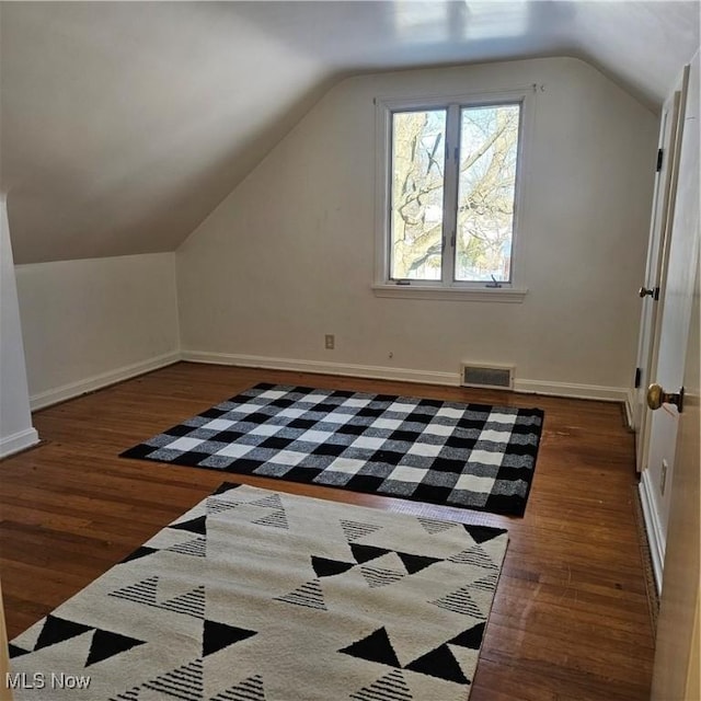 additional living space with lofted ceiling and dark hardwood / wood-style floors