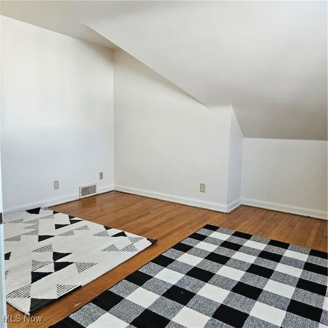 bonus room with lofted ceiling and wood-type flooring