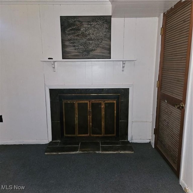 interior details with a tiled fireplace and carpet flooring