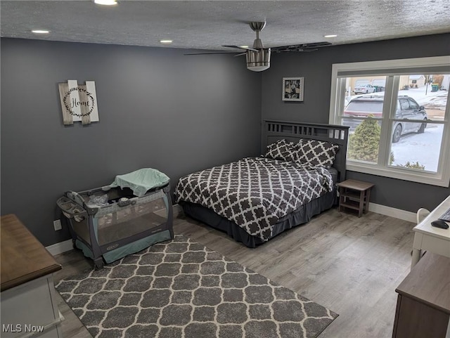 bedroom with hardwood / wood-style floors and a textured ceiling