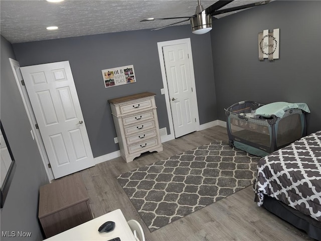 bedroom with hardwood / wood-style floors and a textured ceiling