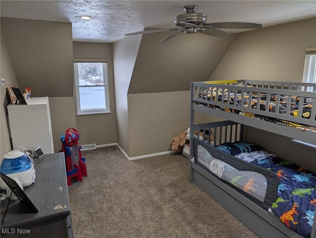 carpeted bedroom featuring vaulted ceiling and a textured ceiling