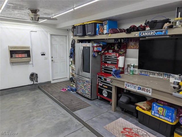 garage featuring heating unit, a workshop area, and ceiling fan