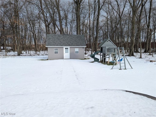 snowy yard featuring a playground