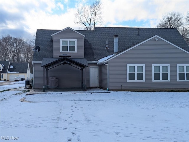 snow covered back of property featuring a gazebo and central AC unit