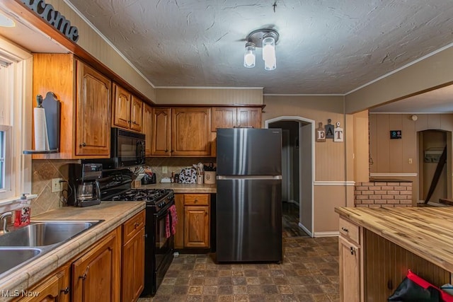 kitchen with ornamental molding, sink, backsplash, and black appliances