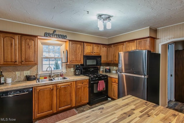 kitchen with dark hardwood / wood-style floors, butcher block countertops, sink, ornamental molding, and black appliances