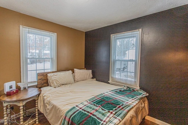 bedroom featuring multiple windows and a textured ceiling