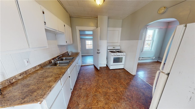 kitchen with sink, white appliances, tasteful backsplash, white cabinets, and a baseboard radiator