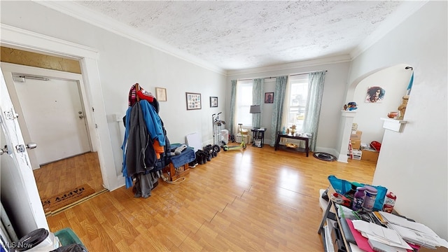 miscellaneous room featuring ornamental molding, light hardwood / wood-style floors, and a textured ceiling