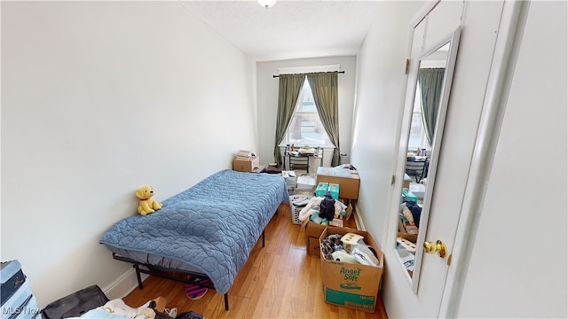 bedroom with a textured ceiling and light wood-type flooring