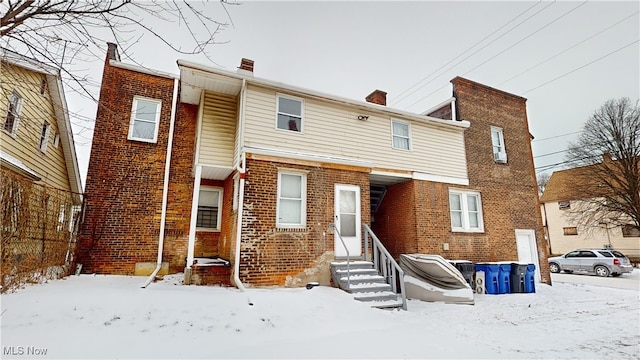 view of snow covered back of property