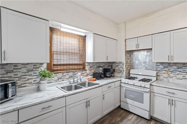 kitchen with sink, white cabinets, and white gas stove