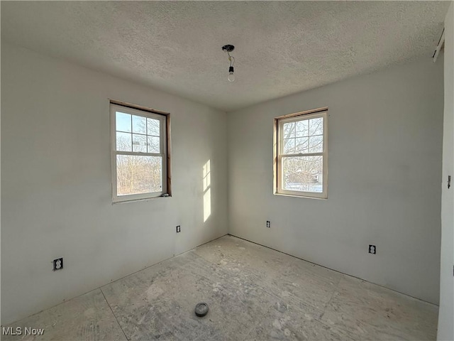 unfurnished room with plenty of natural light and a textured ceiling