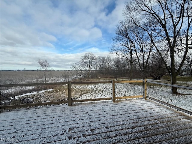 snow covered deck featuring a rural view