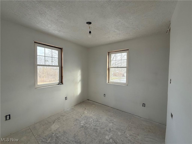 unfurnished room featuring plenty of natural light and a textured ceiling