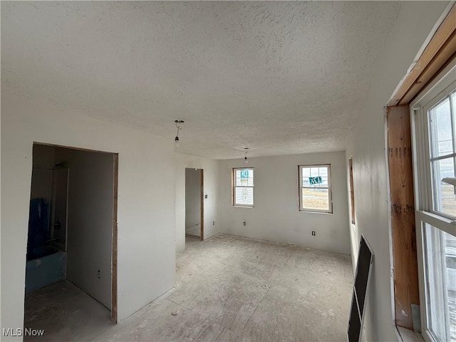 unfurnished room with a textured ceiling