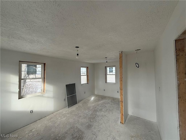 unfurnished room with a textured ceiling