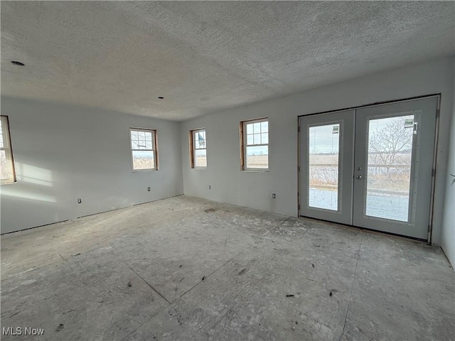 spare room featuring a textured ceiling and french doors