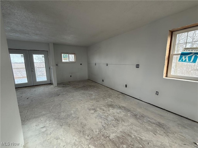 unfurnished room featuring a textured ceiling and french doors