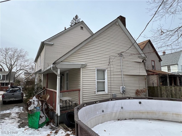 view of snow covered rear of property