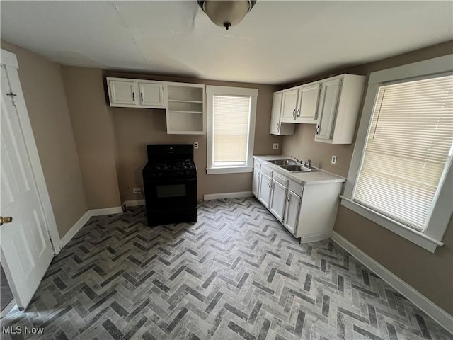 kitchen with sink, white cabinets, and black gas stove