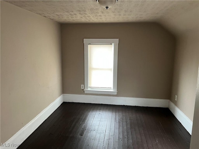 bonus room with dark wood-type flooring, a textured ceiling, and vaulted ceiling