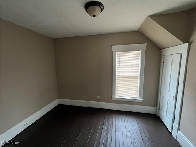 bonus room with dark wood-type flooring and vaulted ceiling