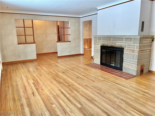 unfurnished living room featuring light hardwood / wood-style flooring and a fireplace